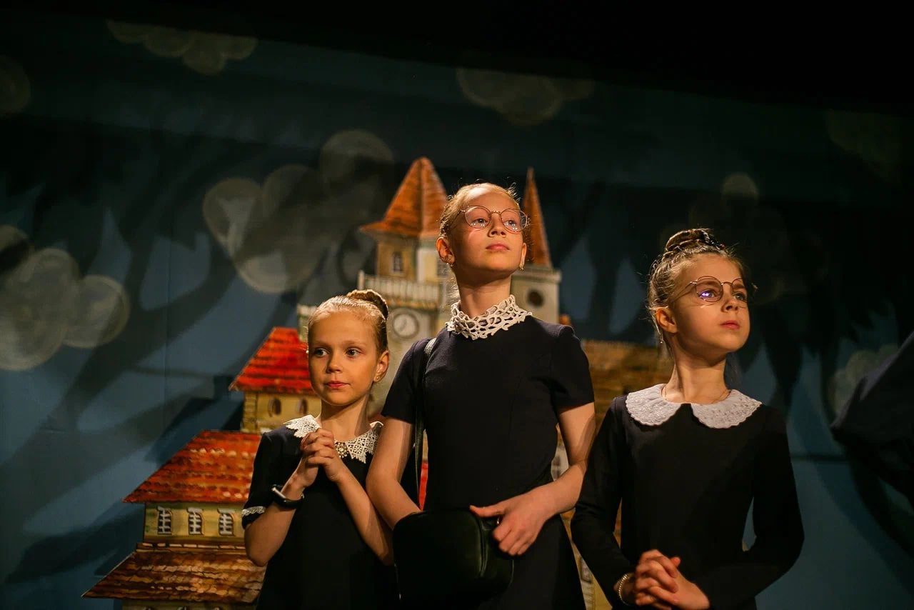 Три девочки из театральной студии Irbis разыгрывают на сцене небольшую постановку