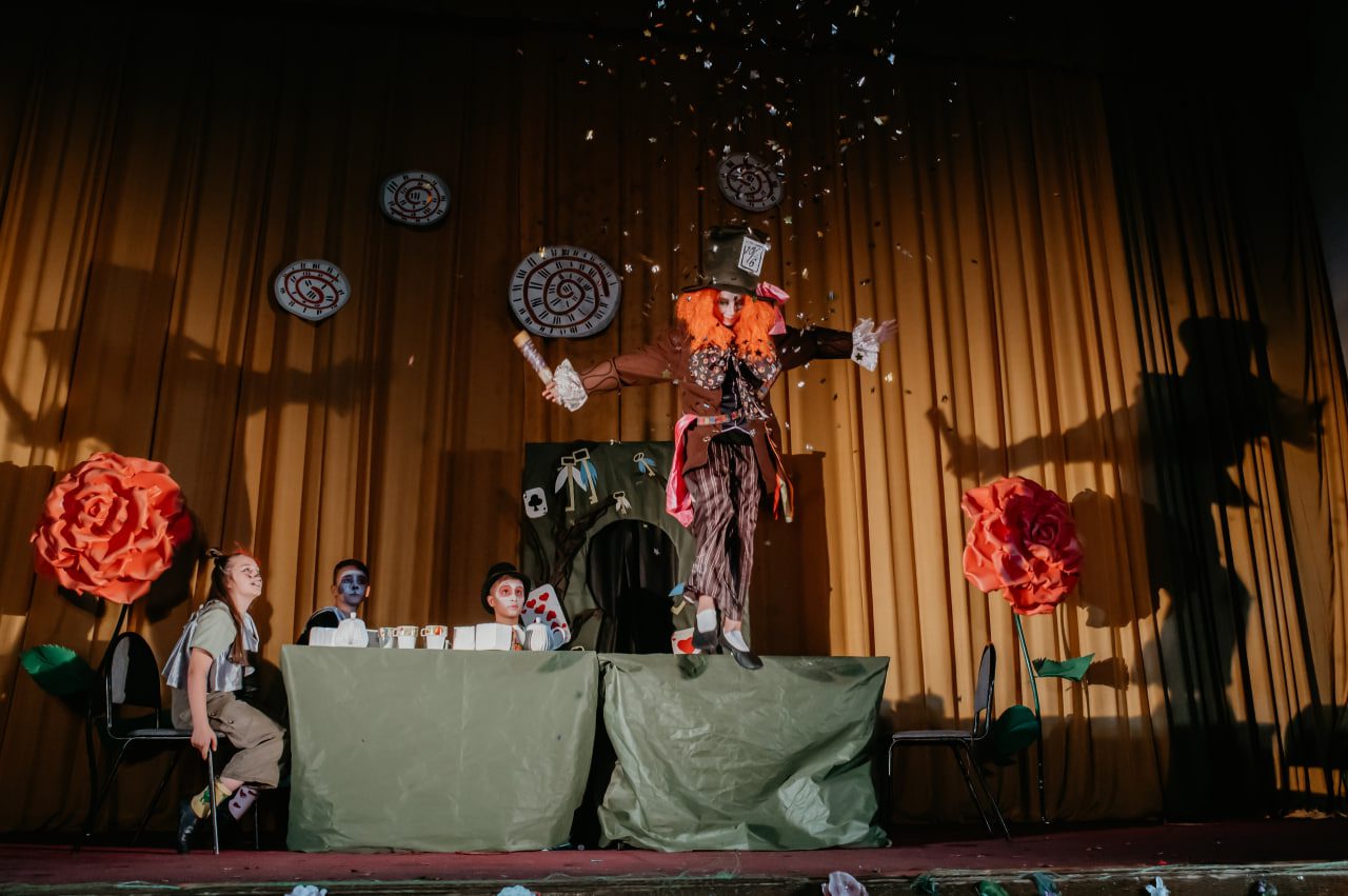 Ребенок в костюме мимика стоя на столе выпускает конфети